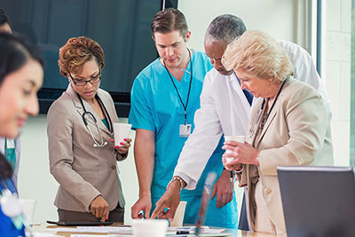 Diverse group of hospital employees studying patient charts